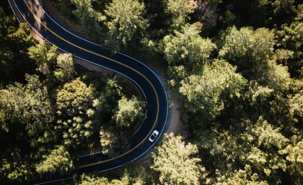 birds eye view of car driving down road